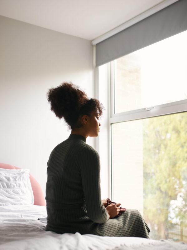 Rear,View,Of,Depressed,Woman,Holding,Face,Mask,Sitting,On